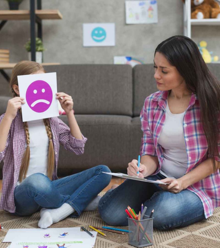 female child protection expert -taking-notes-looking-girl-covering-her-face-with-sad-emotion-card